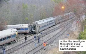  ??  ?? Authoritie­s investigat­e the scene of a fatal Amtrak train crash in South Carolina