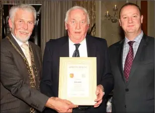  ??  ?? Eddie Pender (centre), the sole surviving team selector, is presented with a scroll by Mayor Jim Moore and Killian Duignan, club chairman.