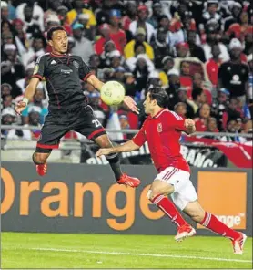  ?? PHOTO: ANTONIO MUCHAVE ?? FLYING: Orlando Pirates winger Tlou Segolela, left, is challenged by Al Ahly ’ s Ahmed Fathi during their Champions League match at Orlando Stadium in Soweto