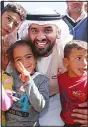  ??  ?? Emirati singer Hussein al-Jasmi (center), poses with Iraqi children during a visit on behalf of Emirates Red Crescent at the Dibaga camp for displaced Iraqis on April 2.