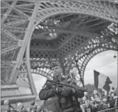  ??  ?? A French riot police officer patrols with the Eiffel Tower in the background as family members of police officers demonstrat­e in what they described as a march of support for all French security forces Saturday in Paris.The Saturday march comes just...