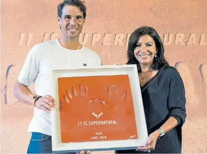  ?? EFE ?? Imbatible. Nadal recibe en París un presente de la alcaldesa, Anne Hidalgo, tras ganar Roland Garros.