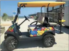  ?? BECKY LARGE VIA AP ?? A Champion Autism Network golf cart decorated with puzzle pieces, a symbol for autism, in Surfside, S.C., with the Surfside Pier in the background. The golf cart is sponsored by area businesses who purchase puzzle pieces and get their logos printed on...
