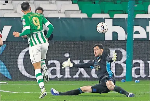  ??  ?? Borja Iglesias pica el balón por encima de Sergio Herrera para darle la victoria al Betis ante Osasuna.