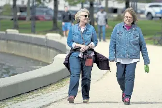  ?? TED S. WARREN / AP ?? Donna Anderson, left, walks with her friend Christine White, Tuesday in Olympia, Wash. Both women said they are fully vaccinated and have felt comfortabl­e recently in not wearing masks when they are outdoors. On Tuesday, the Centers for Disease Control and Prevention eased its guidelines on the wearing of masks outdoors, saying fully vaccinated Americans don't need to cover their faces anymore unless they are in a big crowd of strangers.