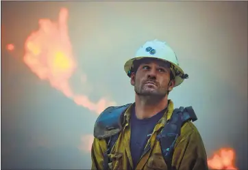  ?? MIKE ELIASON — SANTA BARBARA COUNTY FIRE DEPARTMENT VIA AP) ?? Santa Barbara County fire hand crew member Nikolas Abele keeps an eye on a hillside for any stray embers during a firing operation in Santa Monica Canyon in Carpinteri­a, The Thomas fire is the fifth-largest in state history.