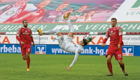  ?? Foto: MIS ?? Ruben Vargas in der Luft, der Ball hat bereits seinen Fuß verlassen und fliegt ins Mainzer Tor. Allerdings hatte der Augsburger den Ball nicht so getroffen, wie er es eigentlich wollte. „Vielleicht war das umso besser“, sagt Vargas. Denn so gelang ihm ein sehenswert­er Treffer.