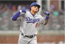  ?? Hyosub Shin / Atlanta Journal-Constituti­on / TNS ?? The Dodgers’ Manny Machado celebrates after slamming a three-run homer in the seventh. Machado drove in four runs.