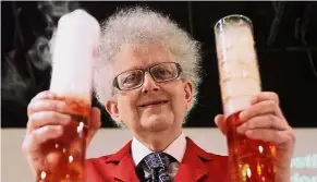  ??  ?? Prof Poliakoff holds two cylinders, which have indicators that change colours once the water becomes acidic after carbon dioxide is added to it.
