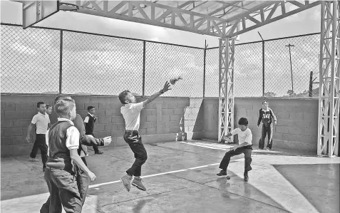  ??  ?? Children play during a break at Aquiles Nazoa Elementary School.