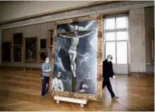  ??  ?? Workers at the Louvre museum transport a painting called “Christ on the Cross Adored by Two Donors” by Spanish painter El Greco, as it returns from an exhibition at the Chicago Institute.