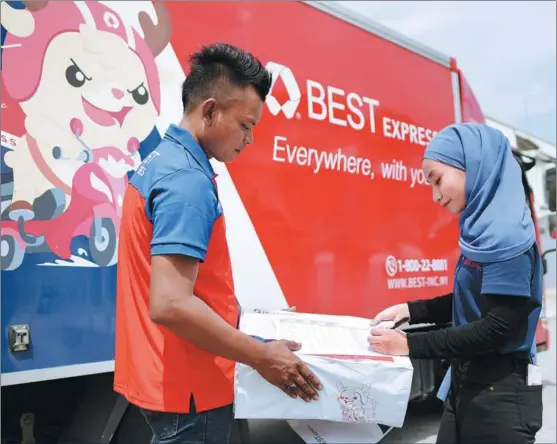  ?? PROVIDED TO CHINA DAILY ?? A woman receives goods from a Best Inc employee in Kuala Lumpur in July.