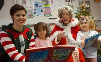  ??  ?? Susan Murphy with Mrs Claus reading to two excited little girls.