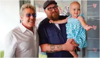  ??  ?? Roger Daltrey, lead singer for the English rock band The Who, left, poses with Adam Kirk and his daughter Sawyer McGhee, a cancer patient, in Cleveland, Ohio, on Monday. — AP photos