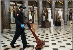  ?? (The New York Times/Anna Moneymaker) ?? A worker pushes a lectern through Statuary Hall at the U.S. Capitol for a news conference Wednesday by House Speaker Nancy Pelosi and other Democrats after the House approved President Joe Biden’s $1.9 trillion coronaviru­s relief package.