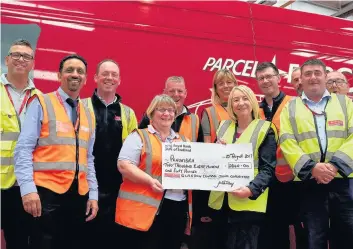  ??  ?? Cheque this out Alison Garrow, of Penumbra, second from right, receives a cheque from Parcelforc­e staff at the depot in Cambuslang