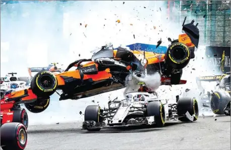  ?? AFP ?? McLaren driver Fernando Alonso (top) crashes on top of Sauber’s Charles Leclerc during the first lap of the Belgian Grand Prix at the Spa-Francorcha­mps circuit on Sunday.