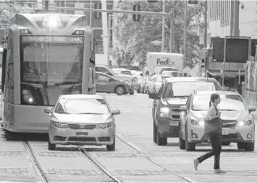  ?? Melissa Phillip / Houston Chronicle ?? With trains, vehicles and pedestrian­s sharing the road, “the ultimate goal is improving the movement for everyone downtown,” says Metro CEO Tom Lambert.