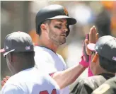  ?? Thearon W. Henderson / Getty Images ?? Justin Ruggiano is congratula­ted after hitting his first home run for the Giants, a solo shot over the center-field wall in the second inning off the Reds’ Lisalverto Bonilla.