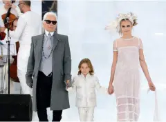  ??  ?? Très souvent, Karl Lagerfeld saluait la foule aux défilés qu’il signait en compagnie de son filleul Hudson Kroenig, le fils du mannequin américain Brad Kroenig. Le garçon et le couturier sont accompagné­s du mannequin Cara Delavingne.