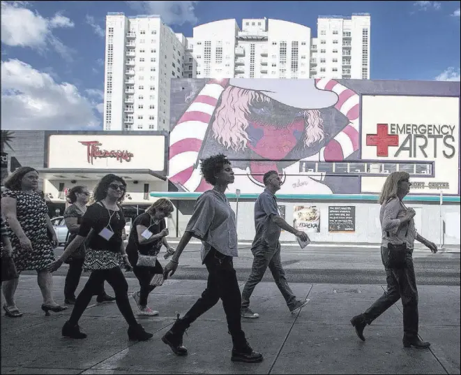  ?? Benjamin Hager Las Vegas Review-Journal @benjaminhp­hoto ?? “Arts at the Heart” conference attendees explore Fremont Street on a cultural walking tour that takes in everything from Main Street to Container Park.