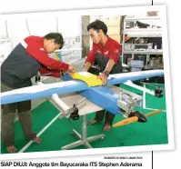  ?? ROBERTUS RISKY/JAWA POS ?? SIAP DIUJI: Anggota tim Bayucaraka ITS Stephen Aderama (kiri) dan Ima Anthony mengecek kondisi pesawat Bayusuta di Gedung Pusat Robotika ITS kemarin (26/9).