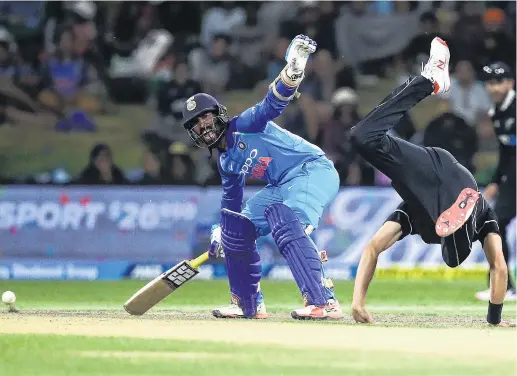  ?? PHOTO: GETTY IMAGES ?? That sort of a night . . . Black Caps paceman Trent Boult takes a tumble, watched by India’s Dinesh Karthik, during the third oneday internatio­nal at the Bay Oval at Mount Maunganui yesterday. India won by seven wickets.