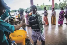  ?? Bloomberg ?? Displaced flood victims queue for tea and snacks at an emergency relief camp in Alappuzha, Kerala on Thursday