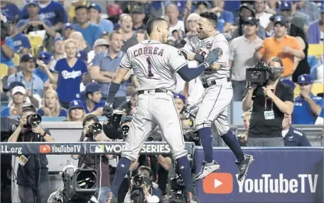  ?? Robert Gauthier Los Angeles Times ?? HOUSTON ASTROS Carlos Correa and Jose Altuve rejoice after hitting back-to-back home runs in the 10th inning of Game 2 at Dodger Stadium. “That’s the guy we know. He’s one of the best hitters in the game,” Houston outfielder Cameron Maybin said of...