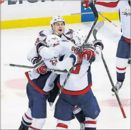  ?? [GENE J. PUSKAR/THE ASSOCIATED PRESS] ?? Washington’s Kevin Shattenkir­k, left, celebrates with Dmitry Orlov and Alex Ovechkin, right, after scoring the game-winning goal in overtime of Game 3 against the Pittsburgh Penguins on Monday in Pittsburgh.