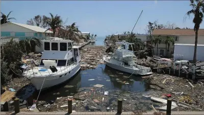  ?? CHIP SOMODEVILL­A, GETTY IMAGES ?? Boats, cars and other debris clog waterways Tuesday in the Florida Keys two days after hurricane Irma slammed into the state in Marathon, Fla. Twelve deaths in Florida have been blamed on Irma, along with four in South Carolina and two in Georgia. At...