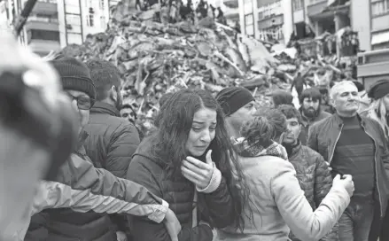  ?? CAN EROK/AFP VIA GETTY IMAGES ?? A woman reacts as rescuers search for survivors in the rubble of collapsed buildings in Adana, Turkey, on Monday after a 7.8 magnitude earthquake struck the country’s southeast.