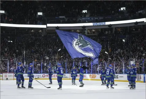  ?? Darryl Dyck/The Canadian Press via AP ?? Vancouver Canucks players gather at center ice to raise their sticks to the fans after defeating the Calgary Flames in the team’s home regular-season finale on Tuesday in Vancouver, British Columbia. Canada’s Cup drought dates to Montreal’s triumph in 1993.