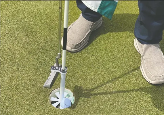  ??  ?? The Cup Caddie, invented by Victor Beda, a Cochrane-based entreprene­ur, allows golfers to use the business end of their putter to hoist their ball out of the hole.