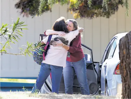  ?? Rich Pedroncell­i / Associated Press ?? Two women embrace outside Rancho Tehama Elementary School, where a gunman opened fire, injuring at least two children.