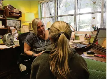  ?? NICOLE VILLALPAND­O/AMERICAN-STATESMAN ?? Mindy Croom consults with a student to make sure her paperwork is in order.