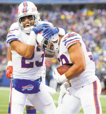  ?? Adrian Kraus / Associated Press ?? Buffalo linebacker Matt Milano (right) is congratula­ted by Micah Hyde (23) after scoring on a fumble return during the first half. It was one of four turnovers committed by the Raiders.