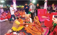  ??  ?? Hundreds of brides in colorful ethnic attire and ornate jewelry performed their wedding rituals in front of thousands of guests in the city of Surat.