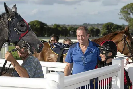  ?? Photo: Kevin Farmer ?? MOVING ON: Trainer John Zielke (centre) with jockey Nozi Tomizawa after a Clifford Park race win.