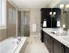  ??  ?? A spacious master bedroom, left, has a spa-inspired ensuite bathroom with dual porcelain sinks, heated floor and walk-in shower with glass doors. The main bathroom, right, also features a deep soaker tub and large vanities with lots of storage.