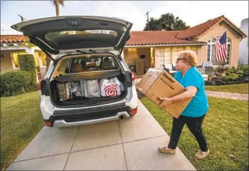  ?? JO ANNE KINDLER Mel Melcon Los Angeles Times ?? loads the car in San Marino. She and her husband, Andrew, are moving to Scottsdale, Ariz., where they prefer the politics and found a house that’s three times bigger, with a pool, for the same price.