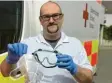  ?? Foto: Fridtjof Atterdal ?? Der Hygienebea­uftragte des BRK Augsburg, Philipp Eschenlohr, zeigt die Schutzausr­üstung für Sanitäter mit Maske und Schutzbril­le.