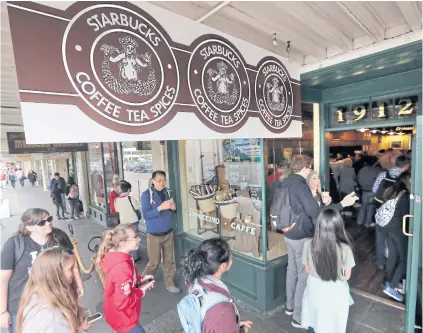  ??  ?? Customers line up to enter a Starbucks, commonly referred to as the original Starbucks, in the Pike Place Market in Seattle on May 29, 2018.