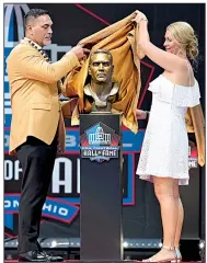  ?? AP/DAVID RICHARD ?? Former offensive lineman
Kevin Mawae (left) and his wife, Tracy, unveil Mawae’s bust during the Pro Football Hall of Fame induction ceremony Saturday.