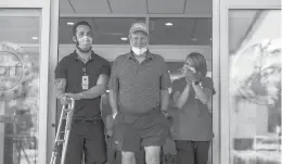  ?? KASSI JACKSON/ HARTFORD COURANT ?? Peter Baldwin walks out of Gaylord Specialty Healthcare with Tim Kilbride, left, a physical therapist, and Katie Zimmerli, right, an occupation­al therapist, after being discharged June 19 in Wallingfor­d after nearly losing his life to COVID-19.