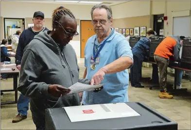  ?? DANA JENSEN THE DAY ?? Moderator Scott Smith, right, helps Theresa Cole with her ballot at the polling station at the Groton Public Library on Tuesday.