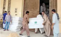  ?? APP ?? Election Commission staffers collecting poll-related material to send to various places at a warehouse of the Election Commission of Pakistan in Islamabad. —