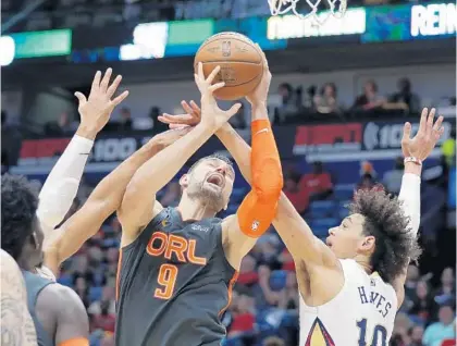  ?? GERALD HERBERT/AP ?? Magic center Nikola Vucevic is fouled as he battles under the basket against Pelicans center Jaxson Hayes (10) in New Orleans on Sunday.