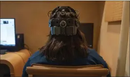  ?? MARY CONLON — THE ASSOCIATED PRESS ?? Emily Hollenbeck, a deep brain stimulatio­n therapy patient, demonstrat­es an EEG device that records brain activity as she reacts to short videos at Mount Sinai's “Q-Lab” in New York on Dec. 20.