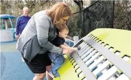  ?? JEFFEREE WOO Tampa Bay Times/TNS ?? Beth Kelly, of New Tampa, holds her 18-month-old grandson, William Kelly, while he plays on a xylophone at the new all-abilities playground in Tampa, Fla.